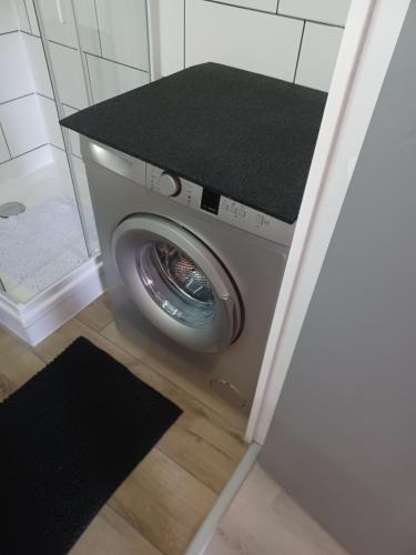 une machine à laver dans une salle de bain avec douche dans l'établissement Appartement en résidence, à Saint-Cyprien