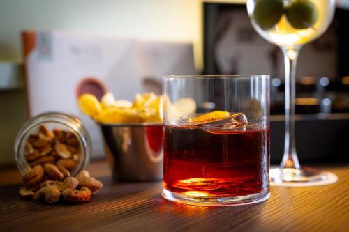 a drink in a glass sitting on a table with a wine glass at Urban Hive Milano in Milan