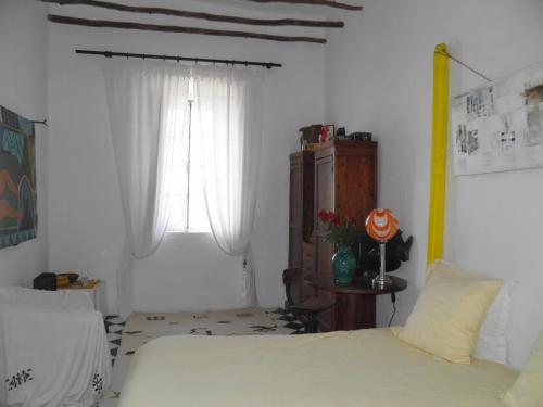 a bedroom with a bed and a window at La Maison des Artistes in Essaouira