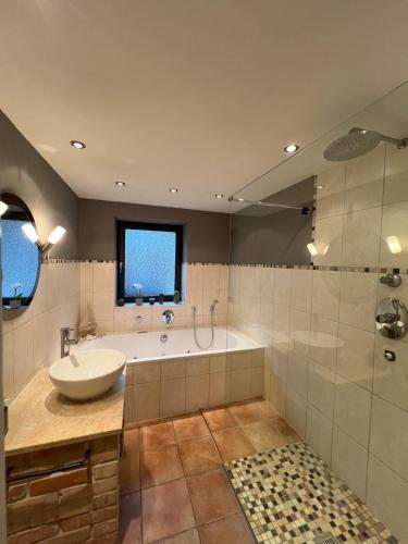 a bathroom with a tub and a sink and a shower at Stay Nice Thermen-Glück 3BR 100qm Whirlpool-Badewanne in Bad Aibling