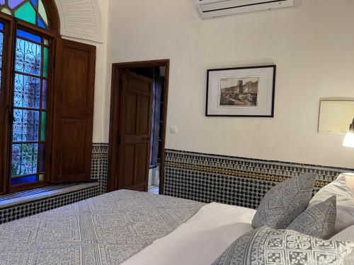 a bedroom with a bed and a stained glass window at Riad Hanael Garden & Spa in Fès