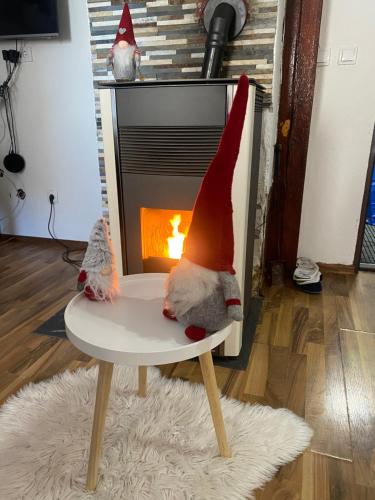 two gnomes sitting on a chair in front of a fireplace at VILA JAHORINSKI RAJ A5 in Jahorina