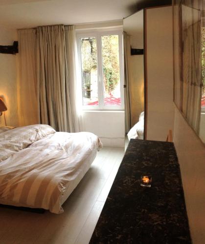 a bedroom with a bed and a large window at Chambres Boufflet in Laon