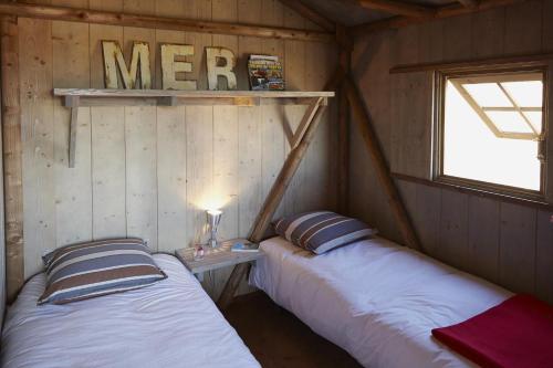 deux lits dans une chambre avec deux fenêtres dans l'établissement Domaine Résidentiel de Plein Air Le Conleau, à Vannes