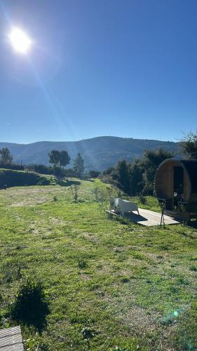 a view of a field with a tent and a hill at Monkey Tiny Barnhouse with amazing views! in Folhadosa