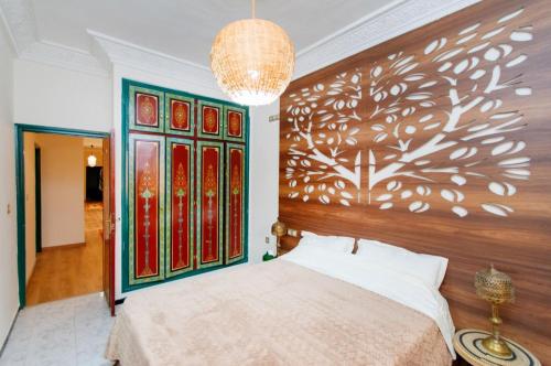 a bedroom with a bed with a large wooden headboard at Palais Rhize targa in Marrakech