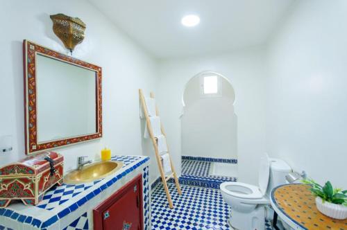 a bathroom with a sink and a toilet and a mirror at Palais Rhize targa in Marrakech
