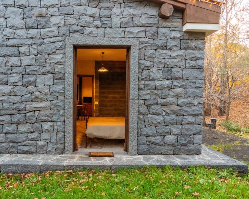 a stone wall with a door leading into a bedroom at Matilde's Chalet Etna Nature House in Nicolosi