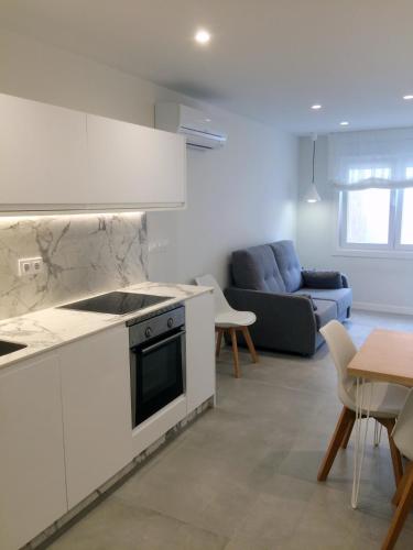 a kitchen and living room with a couch and a table at Apartamentos Angelito Playa América B in Nigrán