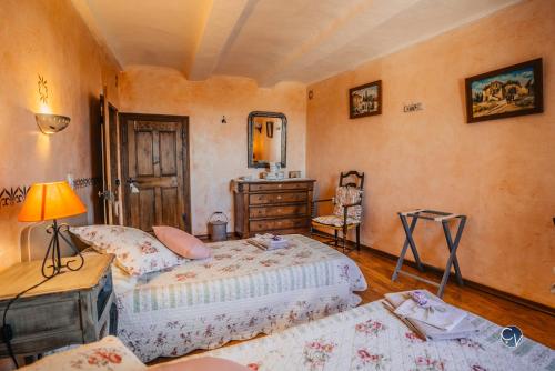 - une chambre avec deux lits, une commode et une chaise dans l'établissement Maison en pierre avec bassin, à La Bastide-dʼEngras