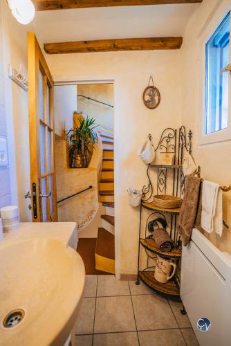 La salle de bains est pourvue d'un lavabo et d'une étagère avec des casseroles et des poêles. dans l'établissement Maison en pierre avec bassin, à La Bastide-dʼEngras