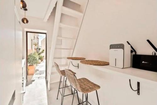 a room with chairs and a counter and stairs at LovelyLoft Santa Cruz in Alicante
