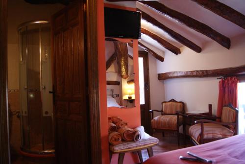 a room with a bed, chair and a dresser at Hotel Casa de la Fuente in Alcorisa