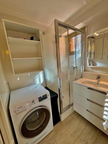 une petite salle de bains avec un lave-linge et un lavabo dans l'établissement 2 pièces face à la mer, à Théoule-sur-Mer