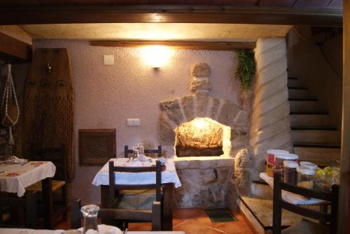 a restaurant with a stone fireplace with a table and chairs at Hotel Casa de la Fuente in Alcorisa