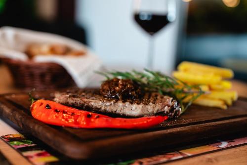 a steak and a carrot on a wooden cutting board at Echinus Lara Hotel in Antalya