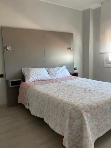 a bedroom with a large bed with a comforter at Apartamentos Angelito Playa América Ático in Nigrán