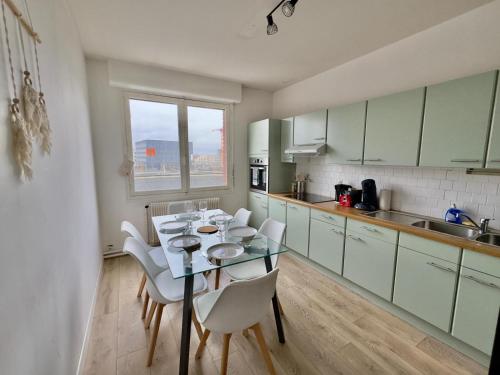 une cuisine avec une table et des chaises dans une cuisine dans l'établissement Le Ciné-Billard du Quai de la Gare-Parking-Balcon, à Amiens