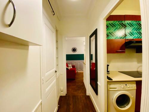 un couloir avec une cuisine et un salon dans l'établissement Appartement Cambronne Jardin Privatif, à Paris