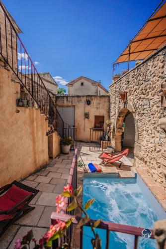- une piscine extérieure dans un bâtiment avec un mur en pierre dans l'établissement Maison en pierre avec bassin, à La Bastide-dʼEngras