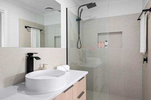 a white bathroom with a sink and a shower at Albury Oasis in Thurgoona