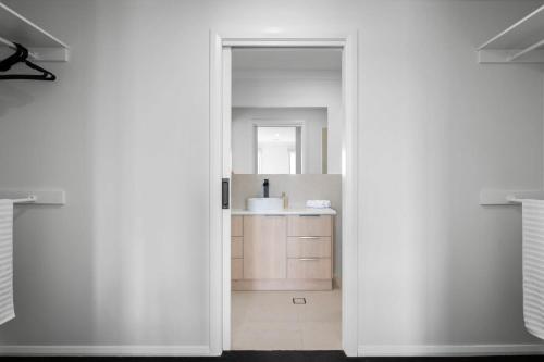 a white bathroom with a sink and a mirror at Albury Oasis in Thurgoona