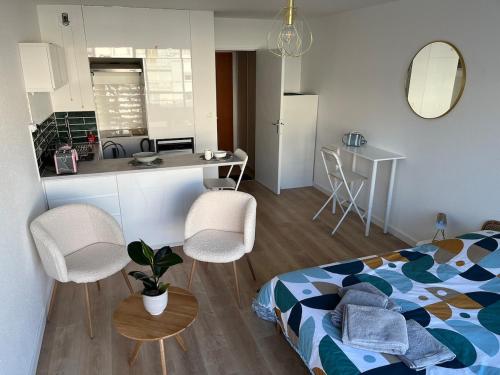 Un pequeño dormitorio con una cama y una cocina. en Joli studio cozy, balcon, Cité des Congrès, Gare Sud, en Nantes