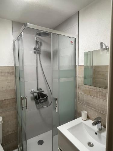 une salle de bain avec une douche en verre et un lavabo dans l'établissement Joli studio cozy, balcon, Cité des Congrès, Gare Sud, à Nantes
