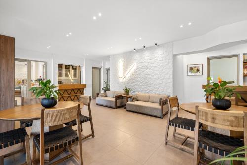 a living room with tables and chairs and a couch at Glaros Hotel Apartment in Agia Galini