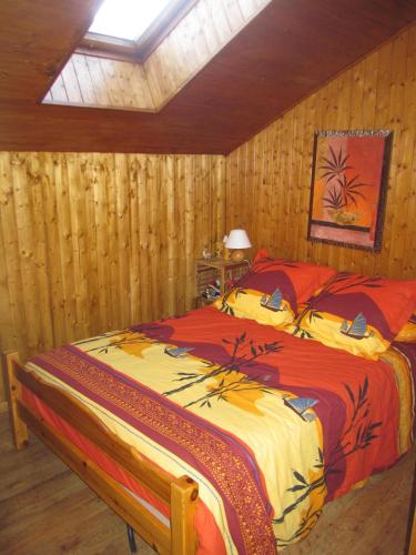 une chambre avec un lit dans une pièce aux murs en bois dans l'établissement F2 Grand Confort en face du télécabine, à Thollon-les-Mémises