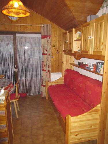- un salon avec un canapé rouge dans une cabine dans l'établissement F2 Grand Confort en face du télécabine, à Thollon-les-Mémises