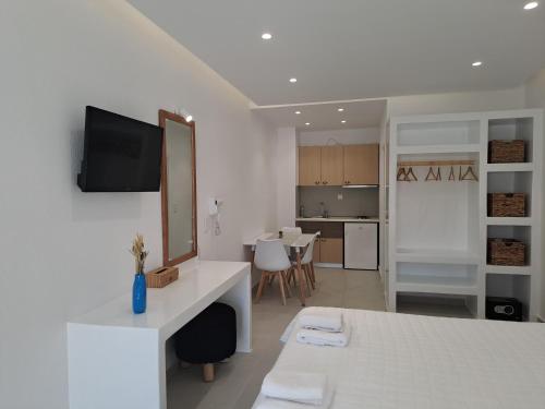 a white room with a bed and a mirror at Anemomilos Beach hotel in Agia Anna Naxos