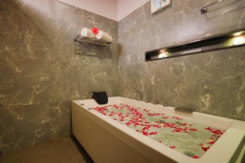a bathroom with a bath tub with red flowers on it at The Grand Retreat - Chikmagalur in Chikmagalūr