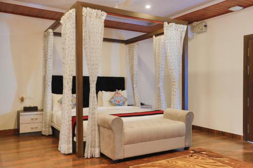 a bedroom with a canopy bed and a couch at The Grand Retreat - Chikmagalur in Chikmagalūr