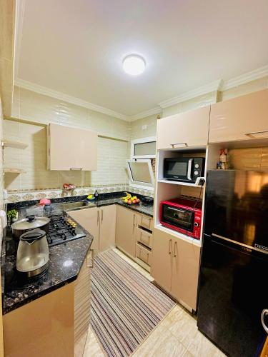 a kitchen with a stove and a refrigerator at 2BD prime apartment in rehab city in New cairo