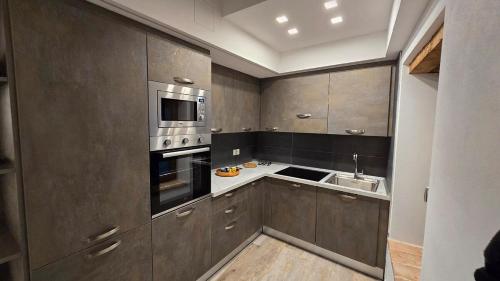 a kitchen with brown cabinets and a sink at Dimora nel borgo in Bibbiena