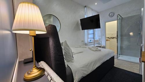 ein Schlafzimmer mit einem Bett mit einer Lampe und einer Dusche in der Unterkunft Teeny tiny in Šentvid