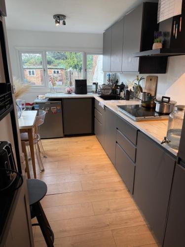 a kitchen with a wooden floor and a counter top at Cozy Double Room in North London with Great Transport Links in Brimsdown Station