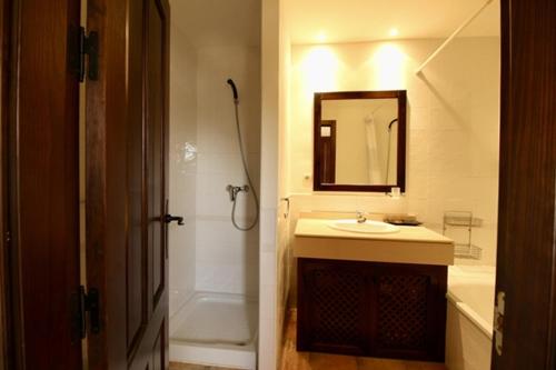 Un baño con lavabo, ducha y espejo. en HL 007 Holiday Rentals 3 bedroom 2 bathroom villa, en Corverica