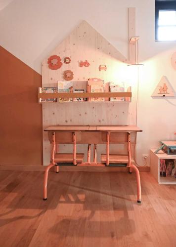a wooden bench in a room with a table at La Grange et le Nid in Saint-Pierre-des-Nids