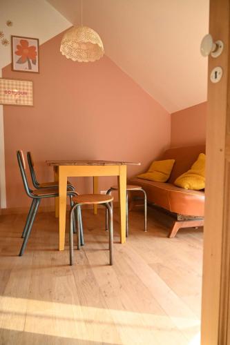 a dining room with a table and chairs and a couch at La Grange et le Nid in Saint-Pierre-des-Nids