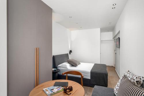 a small bedroom with a bed and a table at Glaros Hotel Apartment in Agia Galini