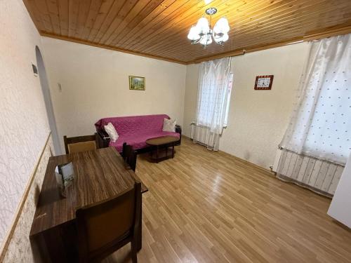 a living room with a pink bed and a table at Gabala Homes Musa in Gabala