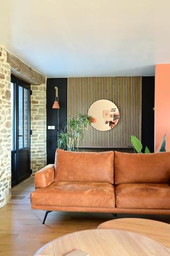 a living room with a brown leather couch at La Grange et le Nid in Saint-Pierre-des-Nids