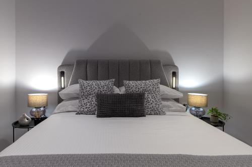 a bedroom with a large white bed with two lamps at Villa Galini in Haraki