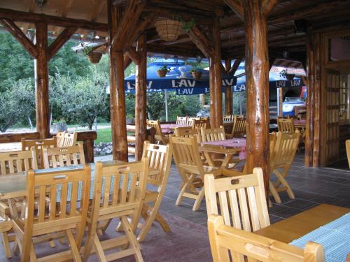 um restaurante vazio com mesas e cadeiras de madeira em Apartments Izvor Lisine em Strmosten