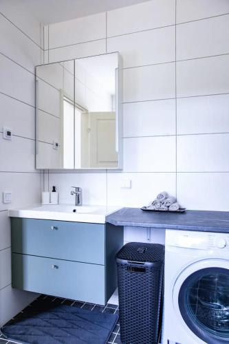 a white bathroom with a washing machine and a sink at Visby Villas in Visby