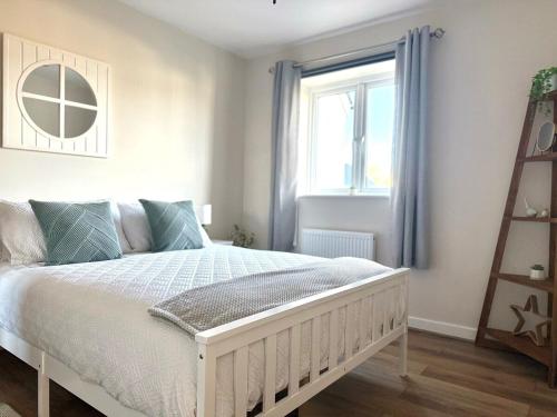 a bedroom with a white bed and a window at Sea Spire Coach House in Charlestown