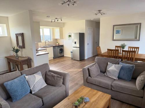 a living room with two couches and a kitchen at Sea Spire Coach House in Charlestown
