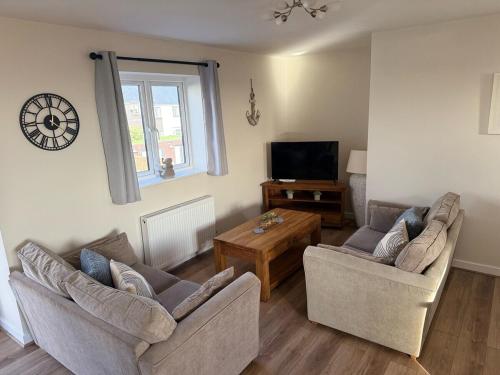 a living room with two couches and a tv at Sea Spire Coach House in Charlestown